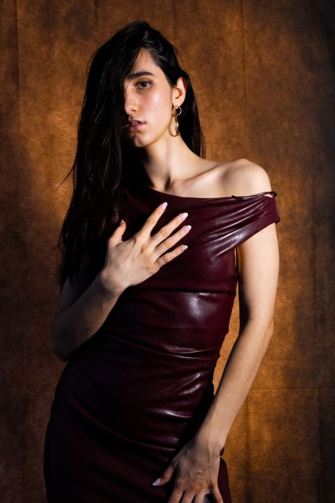 Fotografía profesional de una chica joven y morena con un vestido color vino